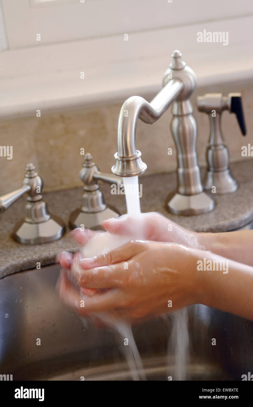 Tight shot of a girl washing her hands in the sink. Stock Photo
