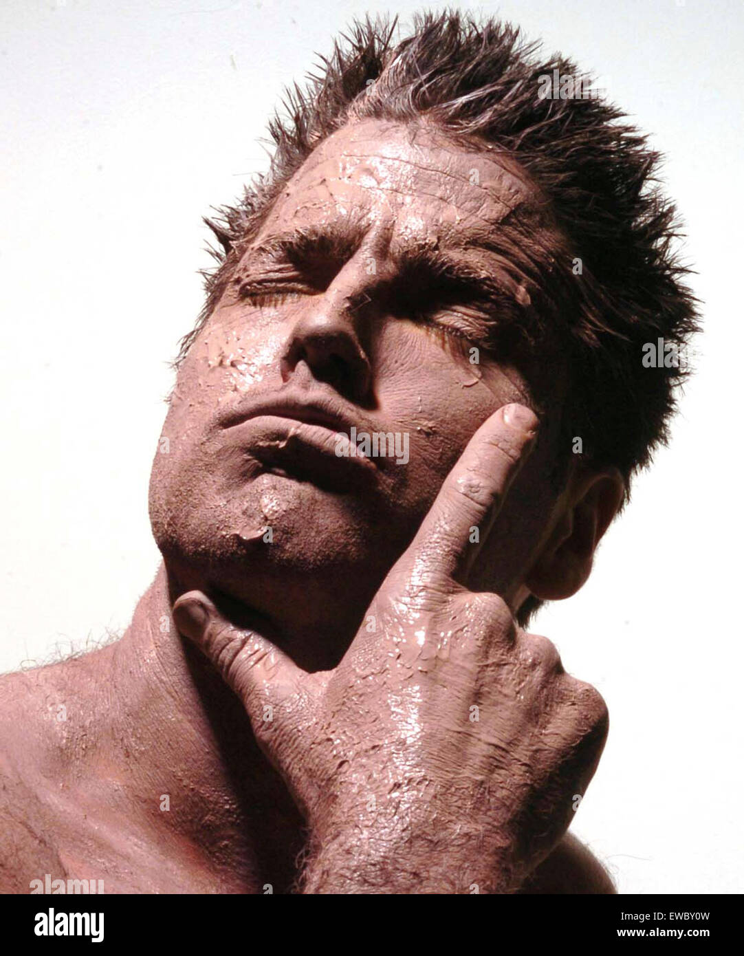 man with mud on his face thinks Stock Photo