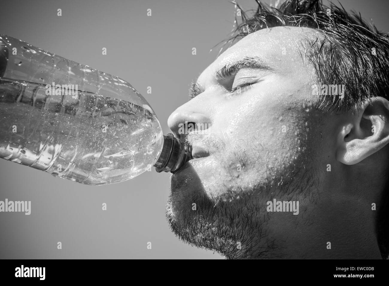 Photo of a man who's face is covered with water. Beautiful sky in the background. Stock Photo