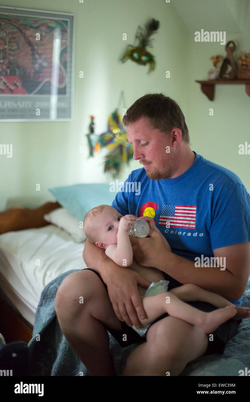 Detroit, Michigan - Adam Hjermstad feeds milk to his 11-month-old son, Adam Hjermstad Jr. Stock Photo