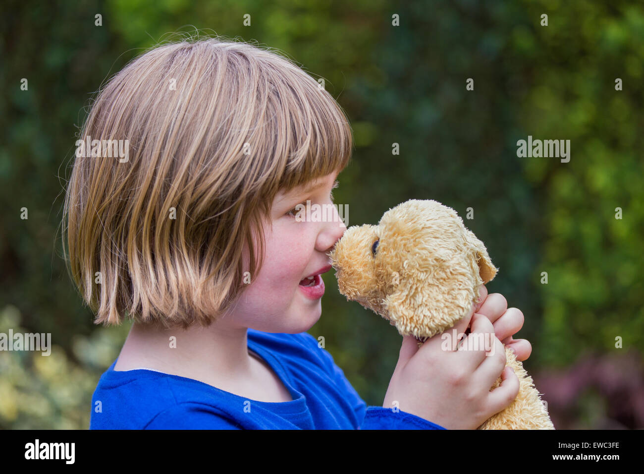 young caucasian girl hugging stuffed dog against her nose Stock Photo