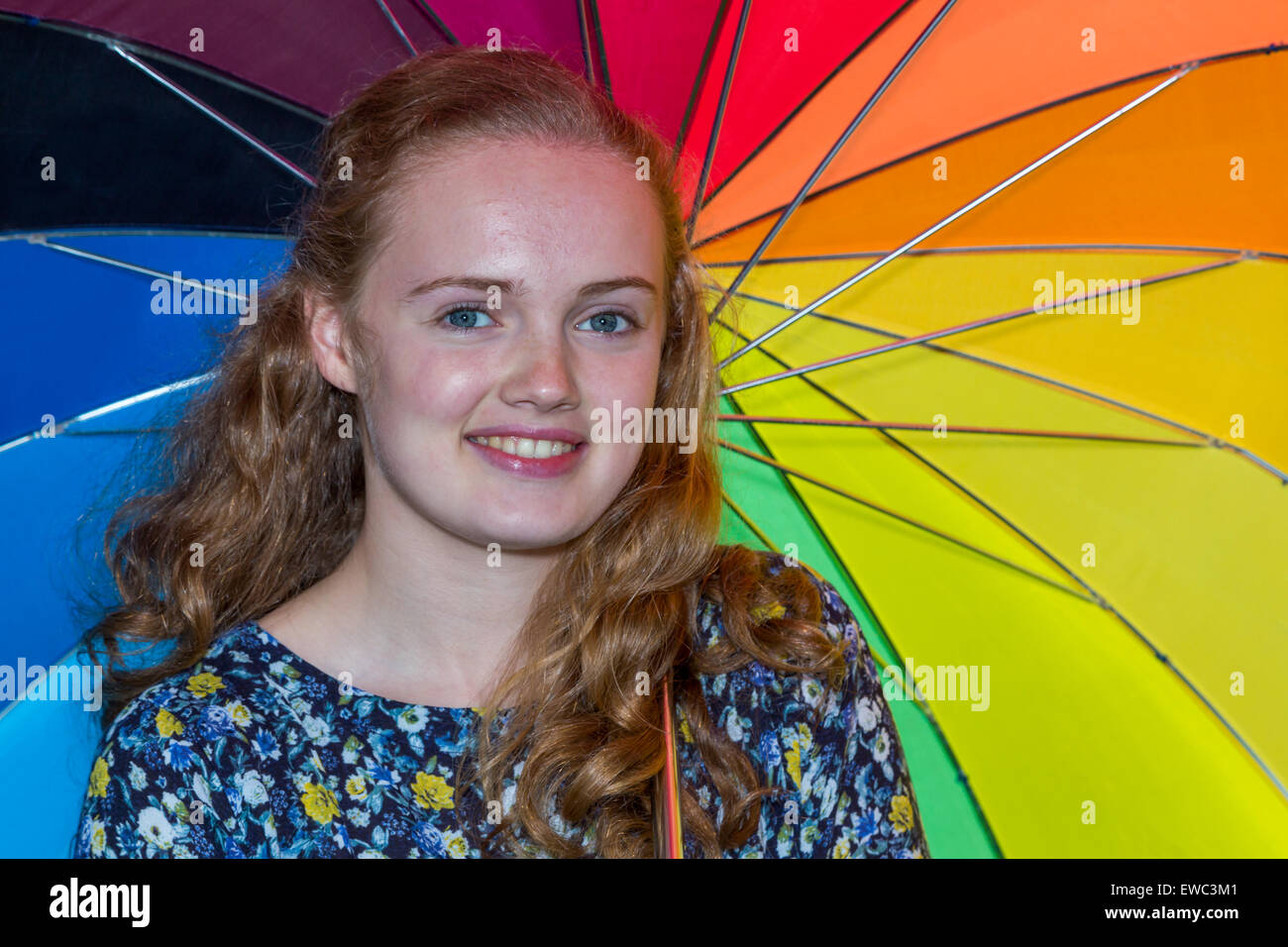Blonde dutch teenage girl under umbrella with various colours Stock Photo