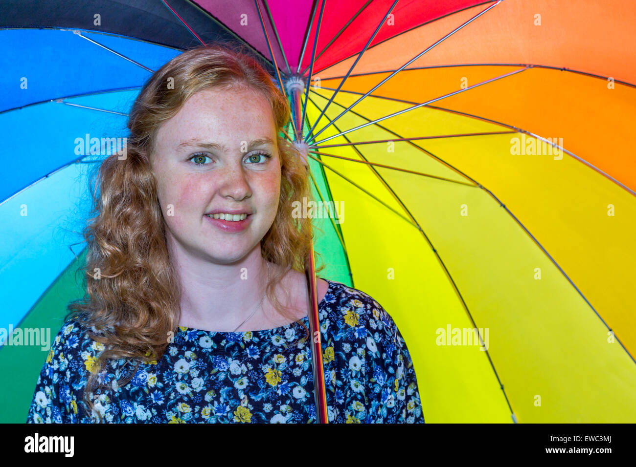 European teenage girl under colored umbrella Stock Photo