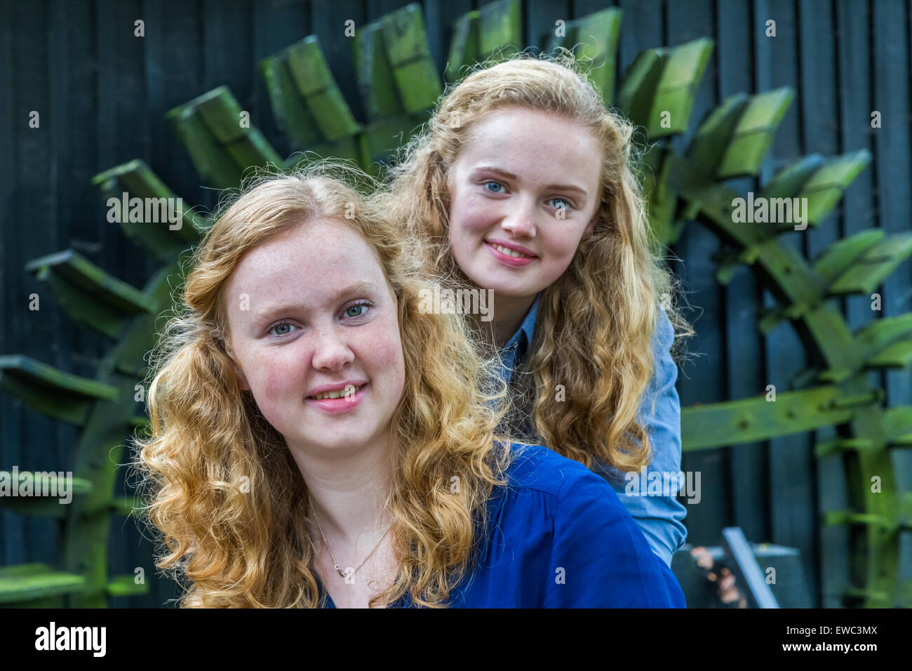 Two european teenage sisters in front of water mill Stock Photo