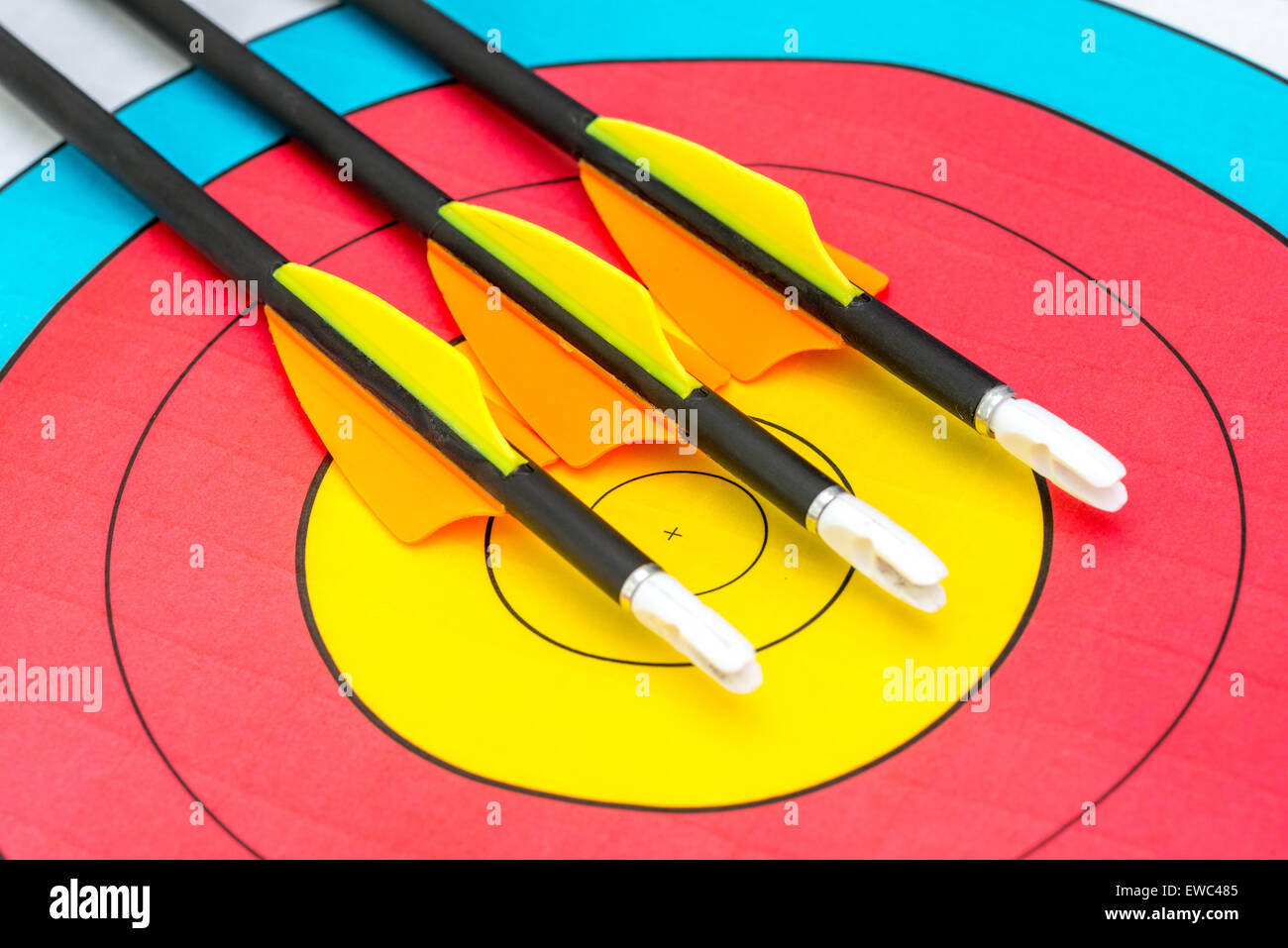 Three arrows sitting on bullseye of a paper target Stock Photo