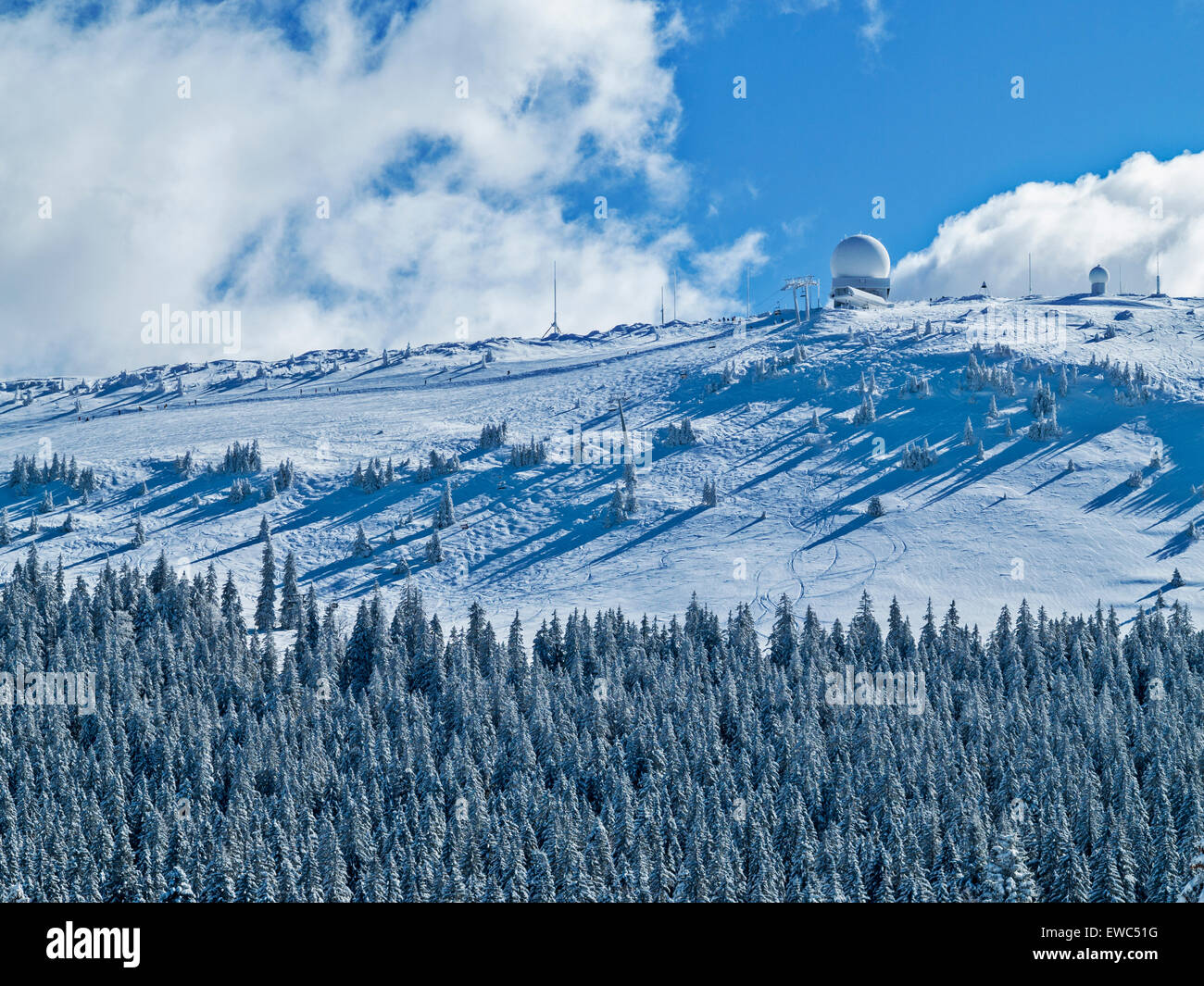 The snow-covered peak of La Dole, highest peak in the Jura mountains, in winter.Ski tracks off the top. Stock Photo