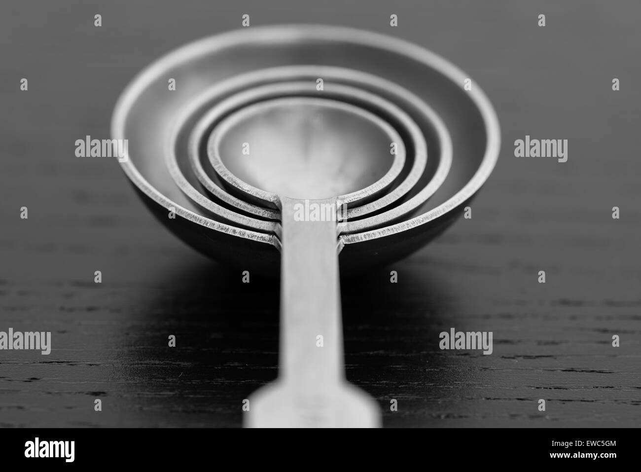 Measuring spoons on a dark worktop Stock Photo