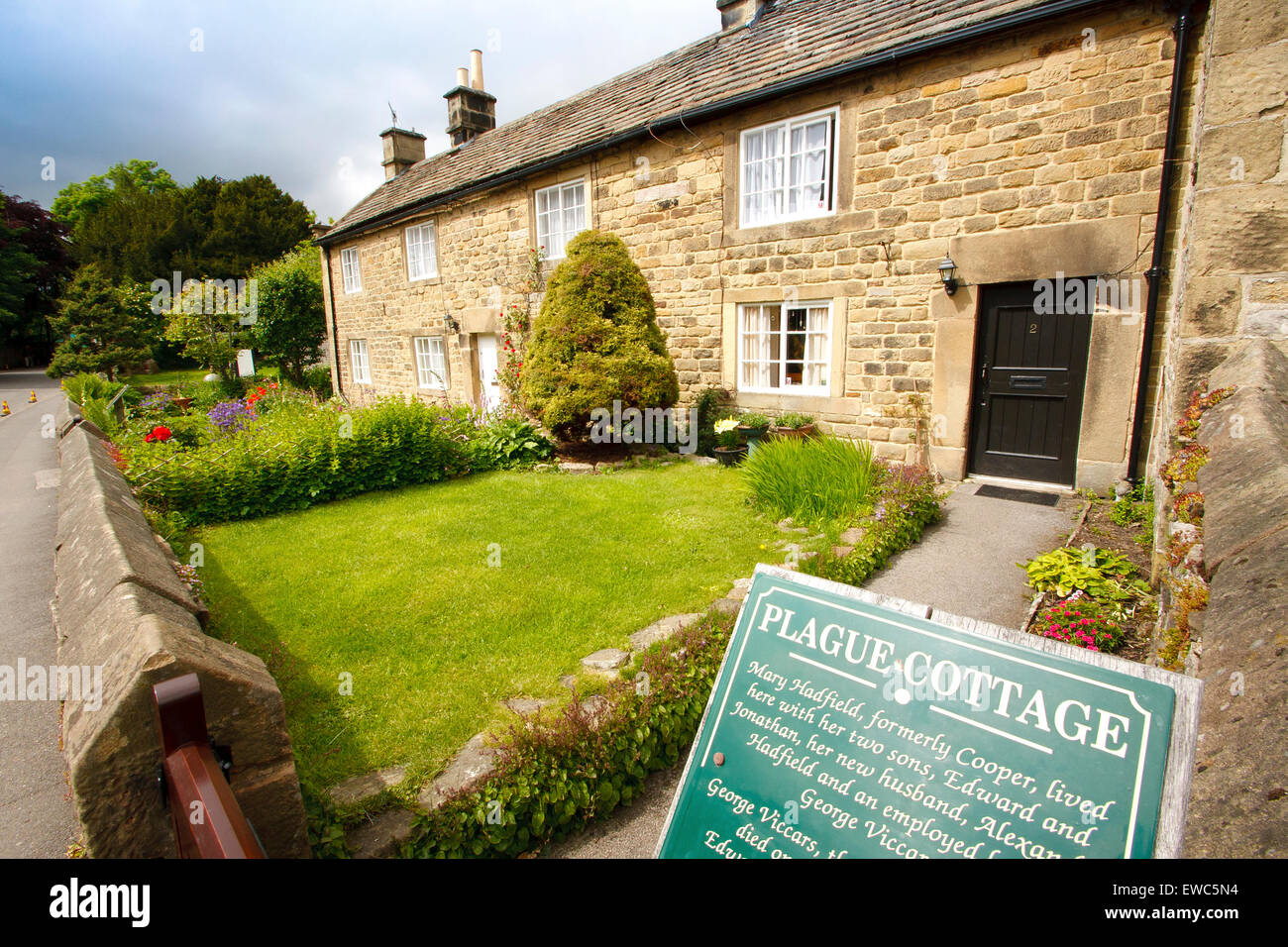 A row of 'plague cottages' where families affected by a plague died in Eyam village, Peak District, Derbyshire, UK - summer Stock Photo