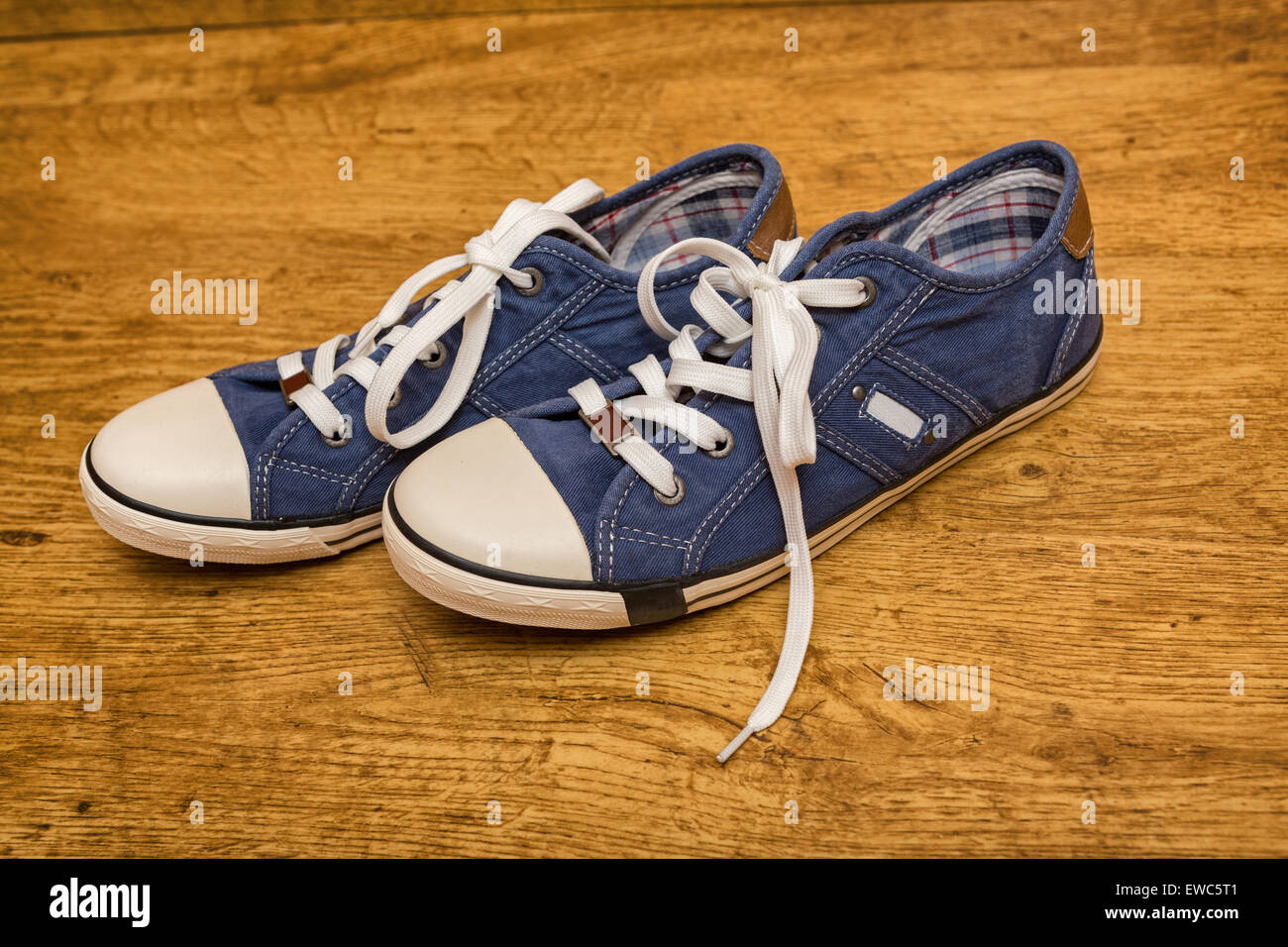 Pair of blue canvas sneakers are on the yellow wood floor Stock Photo ...