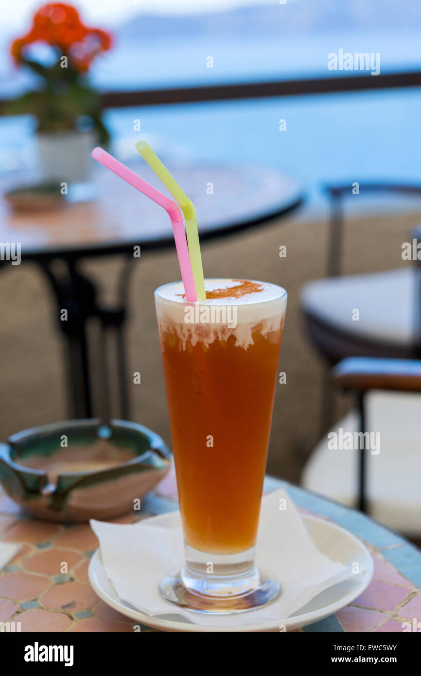 Cocktail with Apple juice with whipped cream in a cafe near the sea Stock Photo