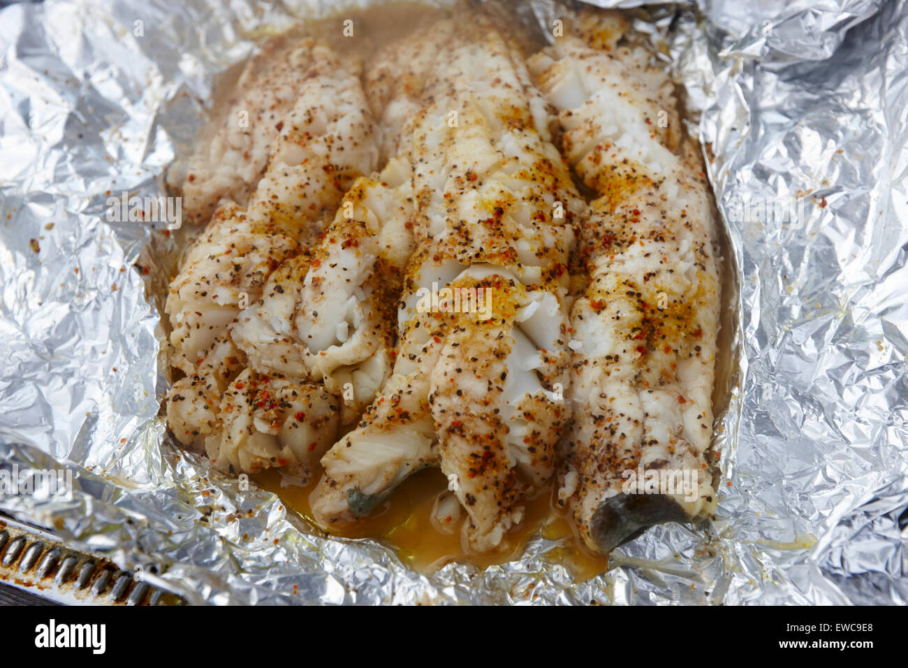 seasoned cod fillets cooked in aluminium foil on a bbq Reykjavik iceland Stock Photo
