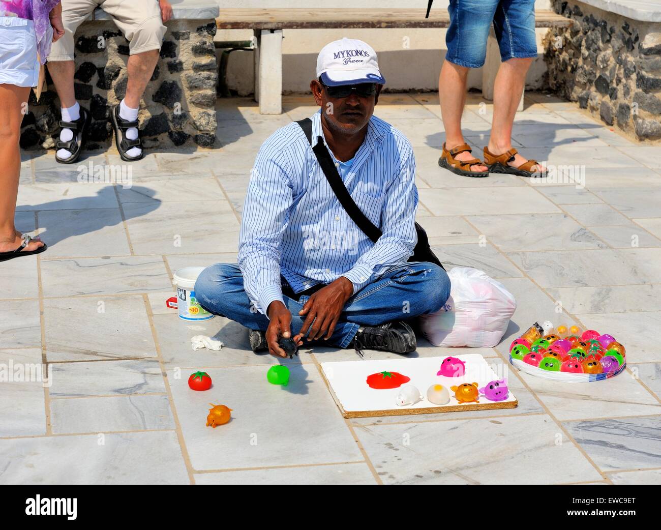 A street seller selling splat toys to tourists in Oia Santorini Greece Stock Photo