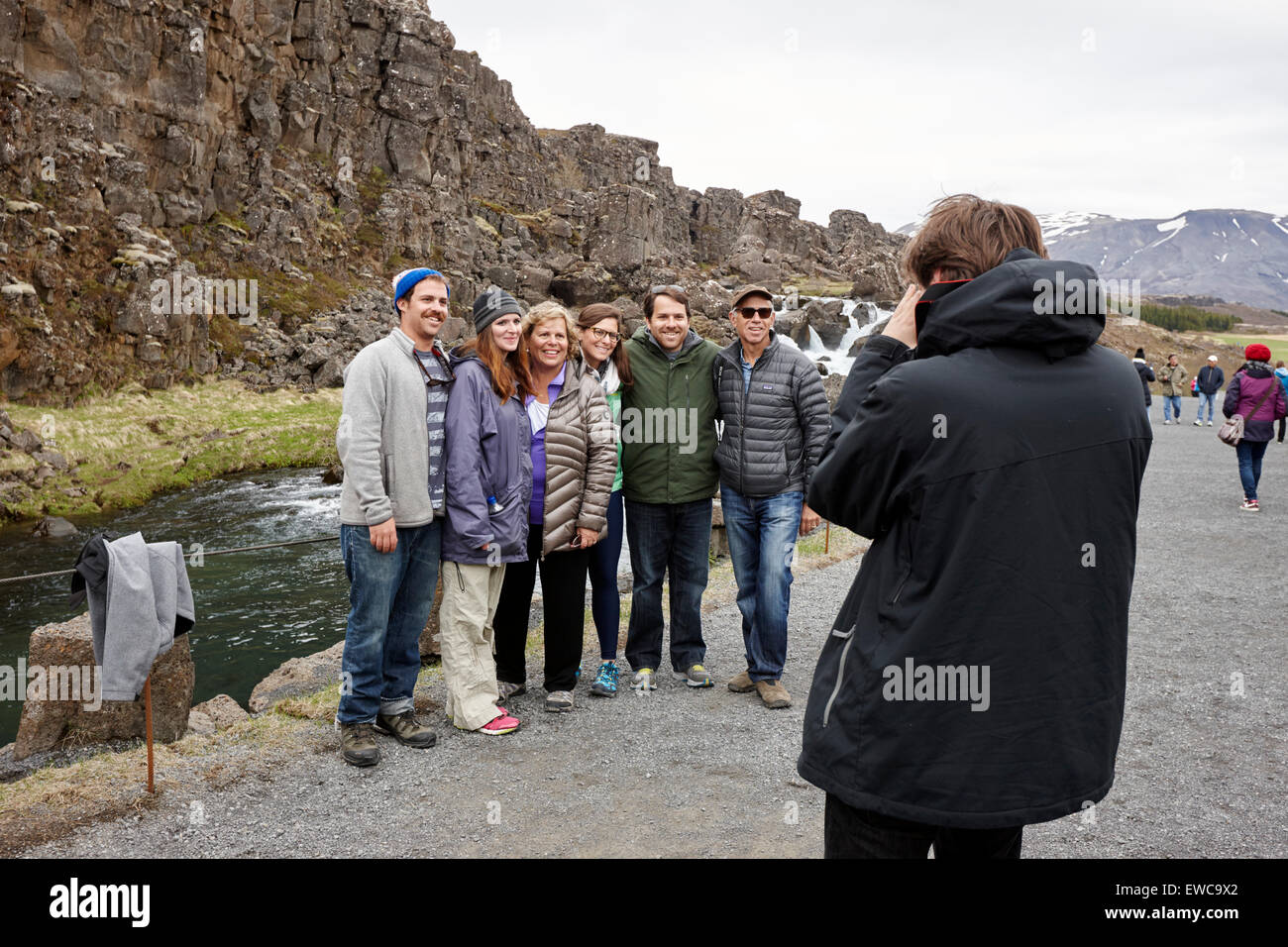 tourists pose for a photo in Almannagja fault line in the mid-atlantic ridge north american plate Thingvellir national park Stock Photo