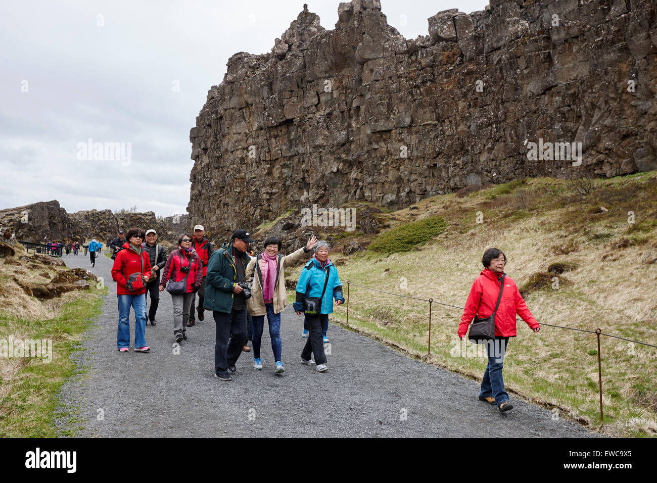 asian tourists walk through the Almannagja fault line in the mid-atlantic ridge north american plate Thingvellir national park Stock Photo