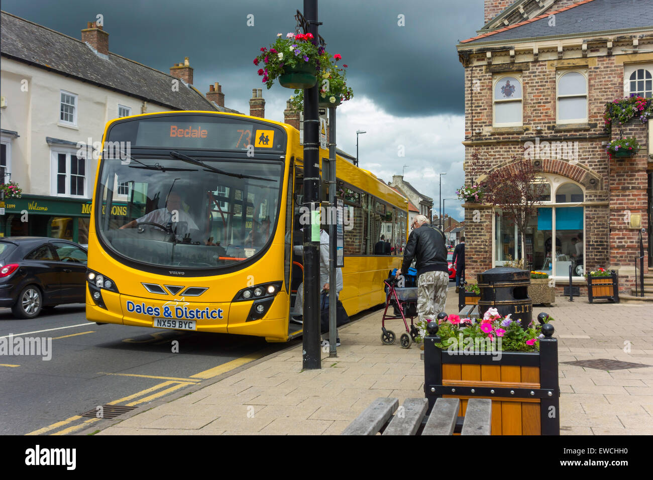 Passengers customers boarding a bright yellow Dales and District Bus to Bedale at Northallerton Town Centre Stock Photo