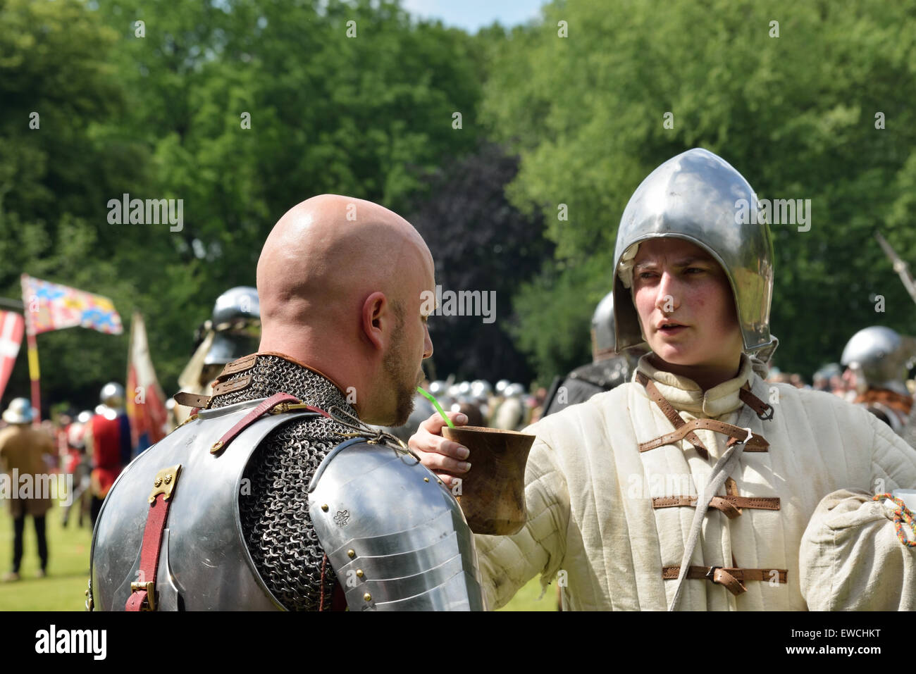 DEURNE, BELGIUM-JUNE 13, 2015: Participant of reconstruction of medieval battle of 1477 drinks water during battle Stock Photo