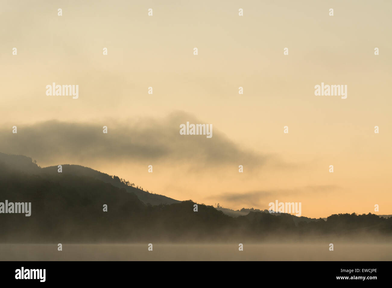 Dawn mist rising above Loch Achray - a small freshwater loch in the Trossachs, Scotland, UK Stock Photo