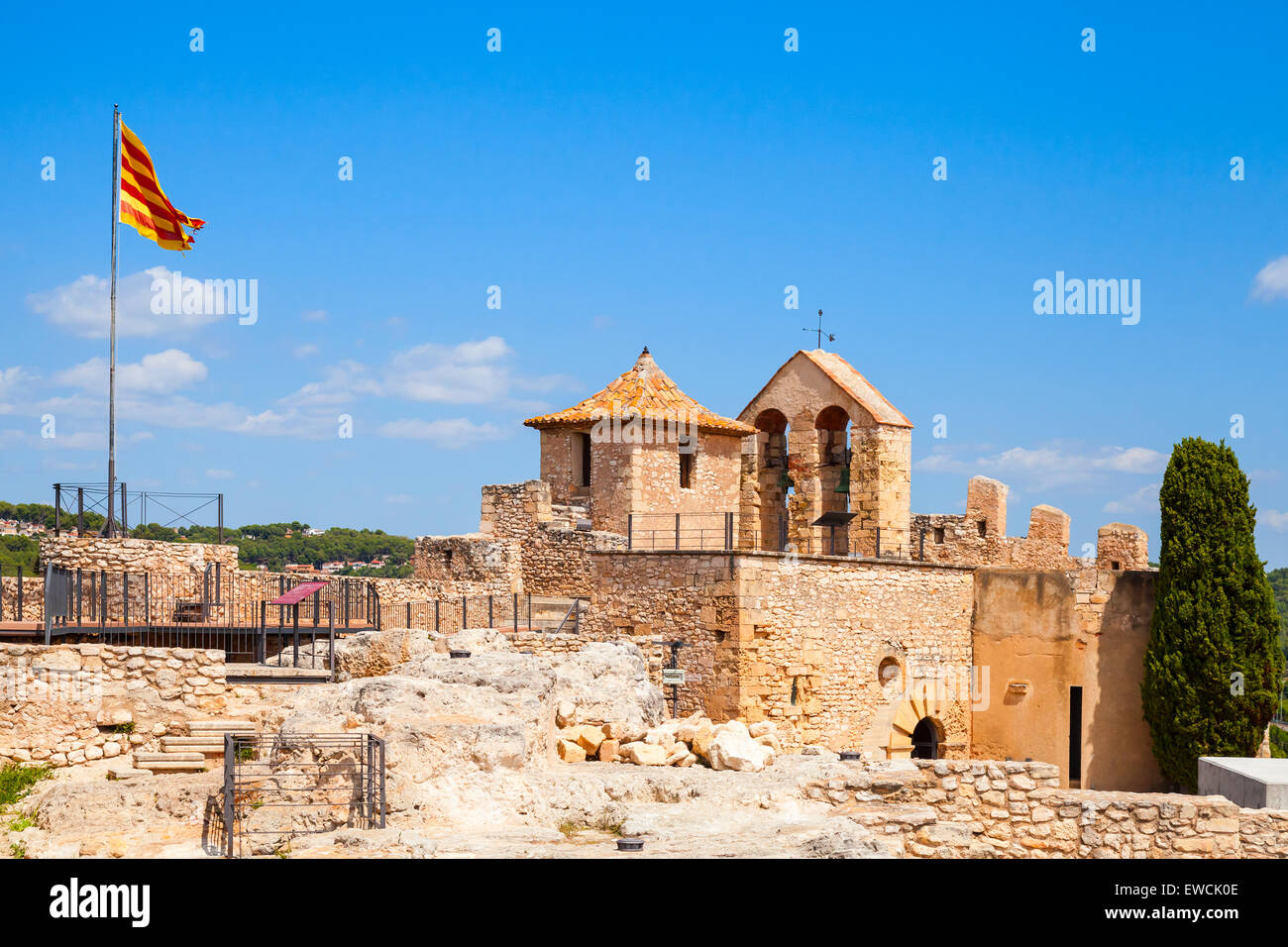 Medieval castle in Calafell town, Spain. Stone towers, walls and striped flag of Catalonia Stock Photo
