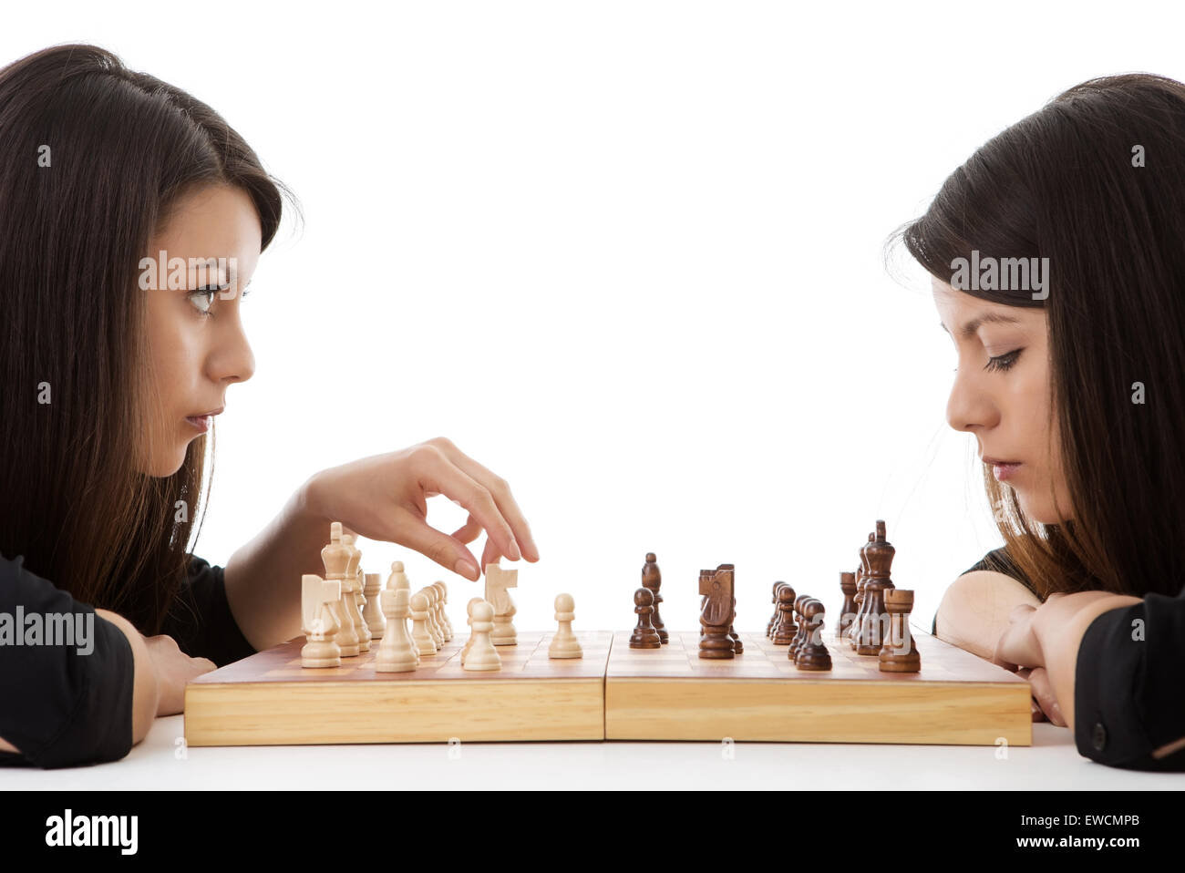 young woman playing chess against herself shot in the studio Stock Photo