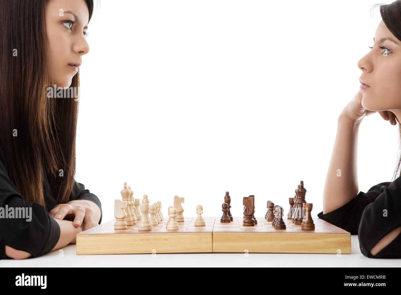 young woman playing chess against herself shot in the studio Stock Photo