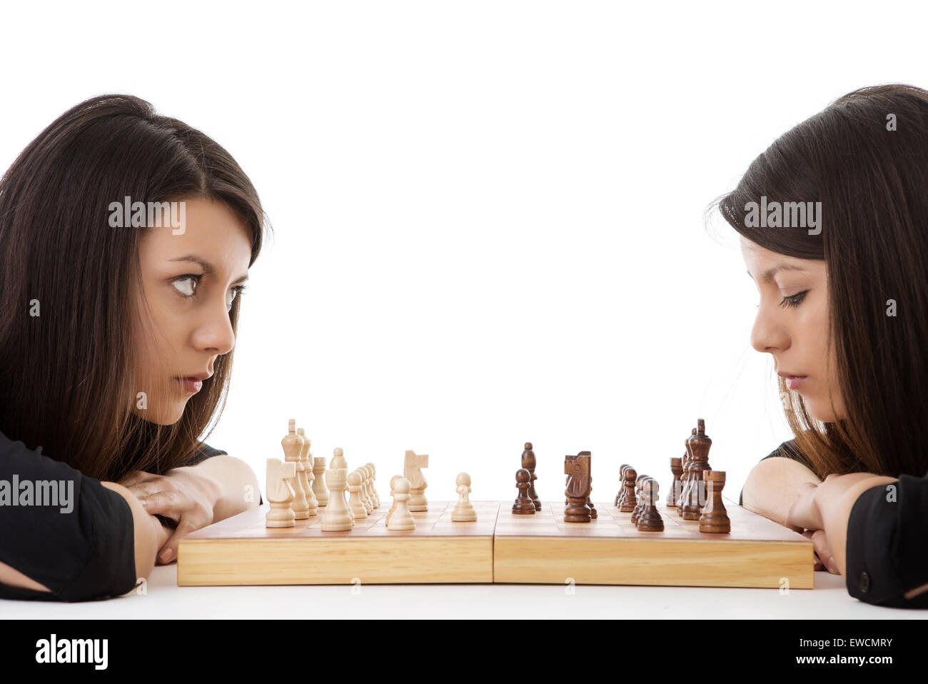 young woman playing chess against herself shot in the studio Stock Photo