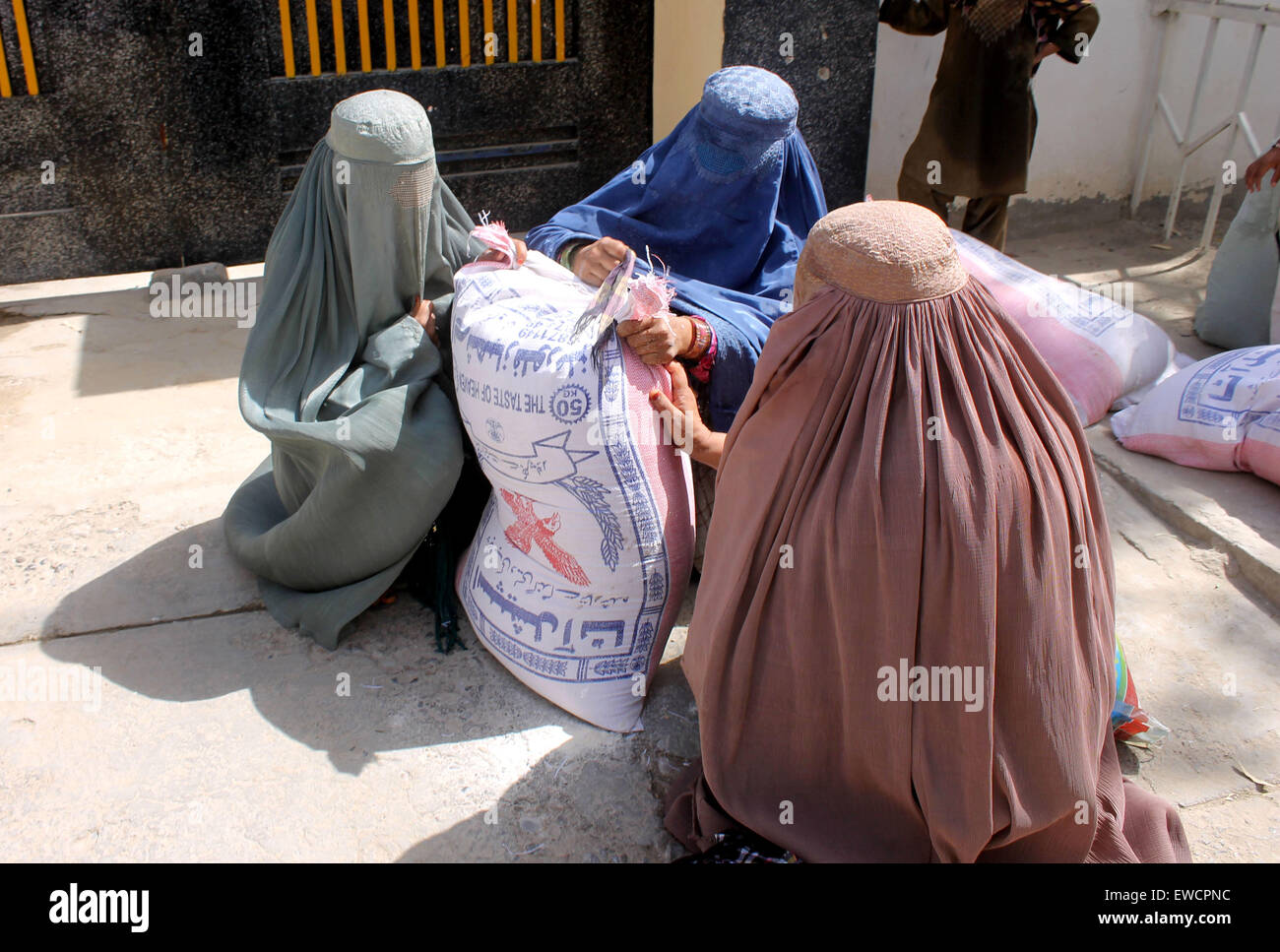 Kandahar, Afghanistan. 23rd June, 2015. Afghan women receive food donated by rich people during the holy month of Ramadan in Kandahar province, southern Afghanistan, June 23, 2015. © Sanaullah/Xinhua/Alamy Live News Stock Photo