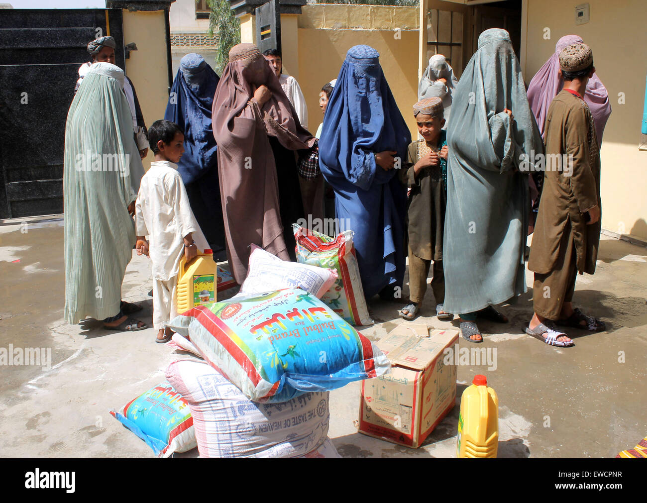 Kandahar, Afghanistan. 23rd June, 2015. Afghan women and children wait to receive food donated by rich people during the holy month of Ramadan in Kandahar province, southern Afghanistan, June 23, 2015. © Sanaullah/Xinhua/Alamy Live News Stock Photo