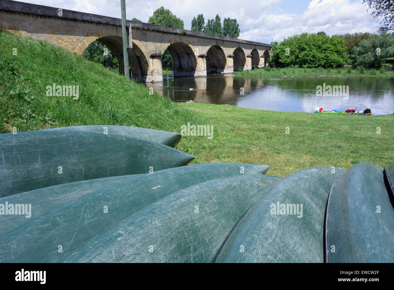 Beached canoes on the bank of the River Dordogne, near the bridge at Castelnaud la Chapelle, Perigord, France Stock Photo