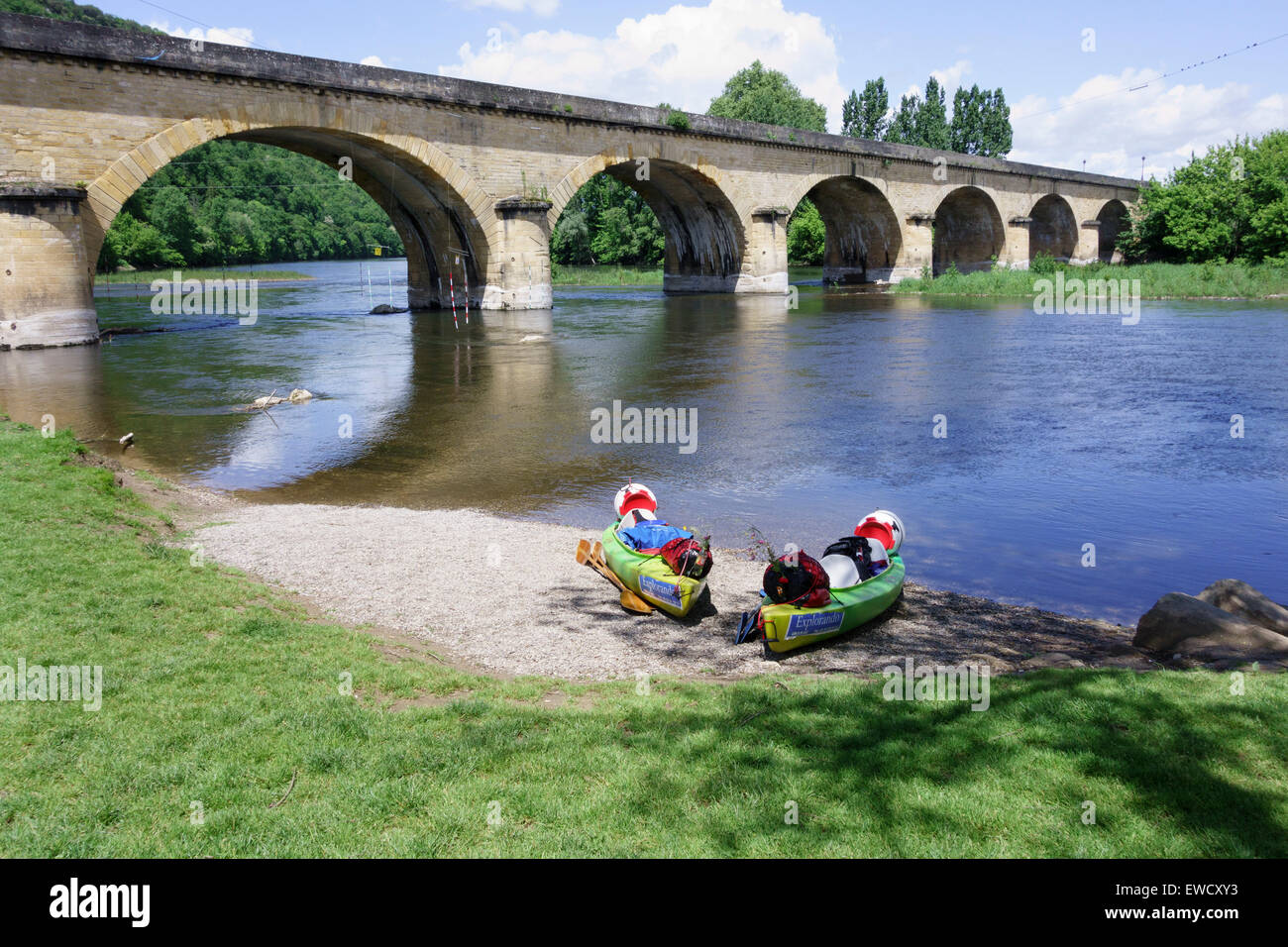 Two kayaks loaded with camping equipment on the bank of the River Dordogne, near the bridge at Castelnaud la Chapelle, France Stock Photo