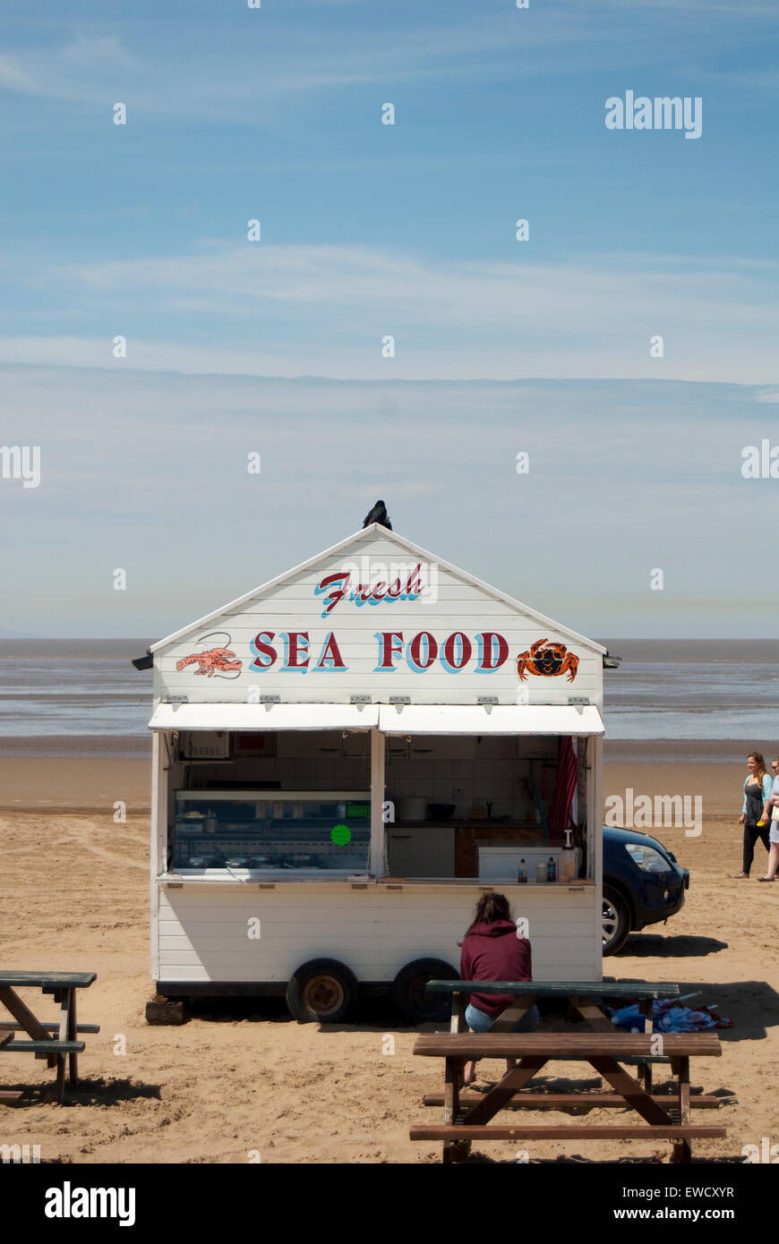 Editorial image showing a seafood seller on the beach at Weston Super