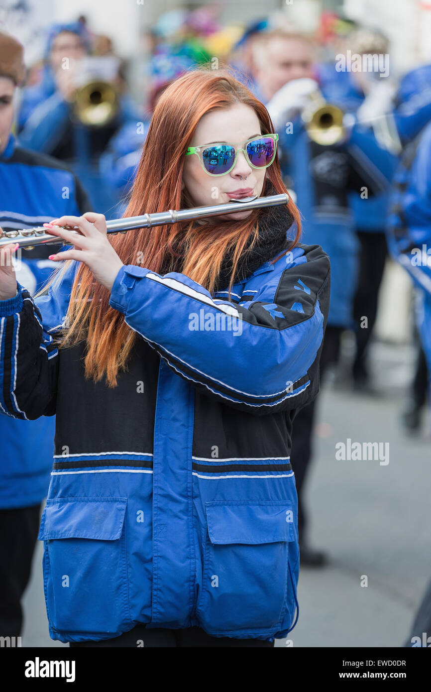 Young woman with red hair playing flute in Cologne Carnival Parade 2014 Stock Photo
