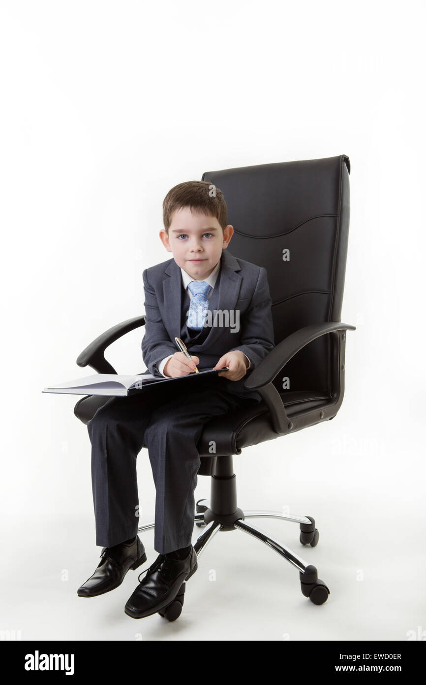 boy sitting in an office chair pretending he s working very hard
