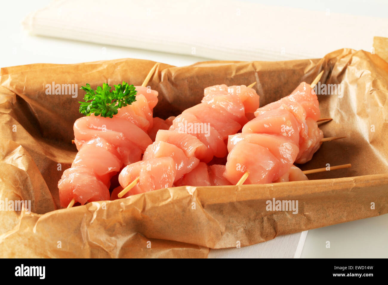 Raw chicken skewers on baking parchment paper Stock Photo Alamy