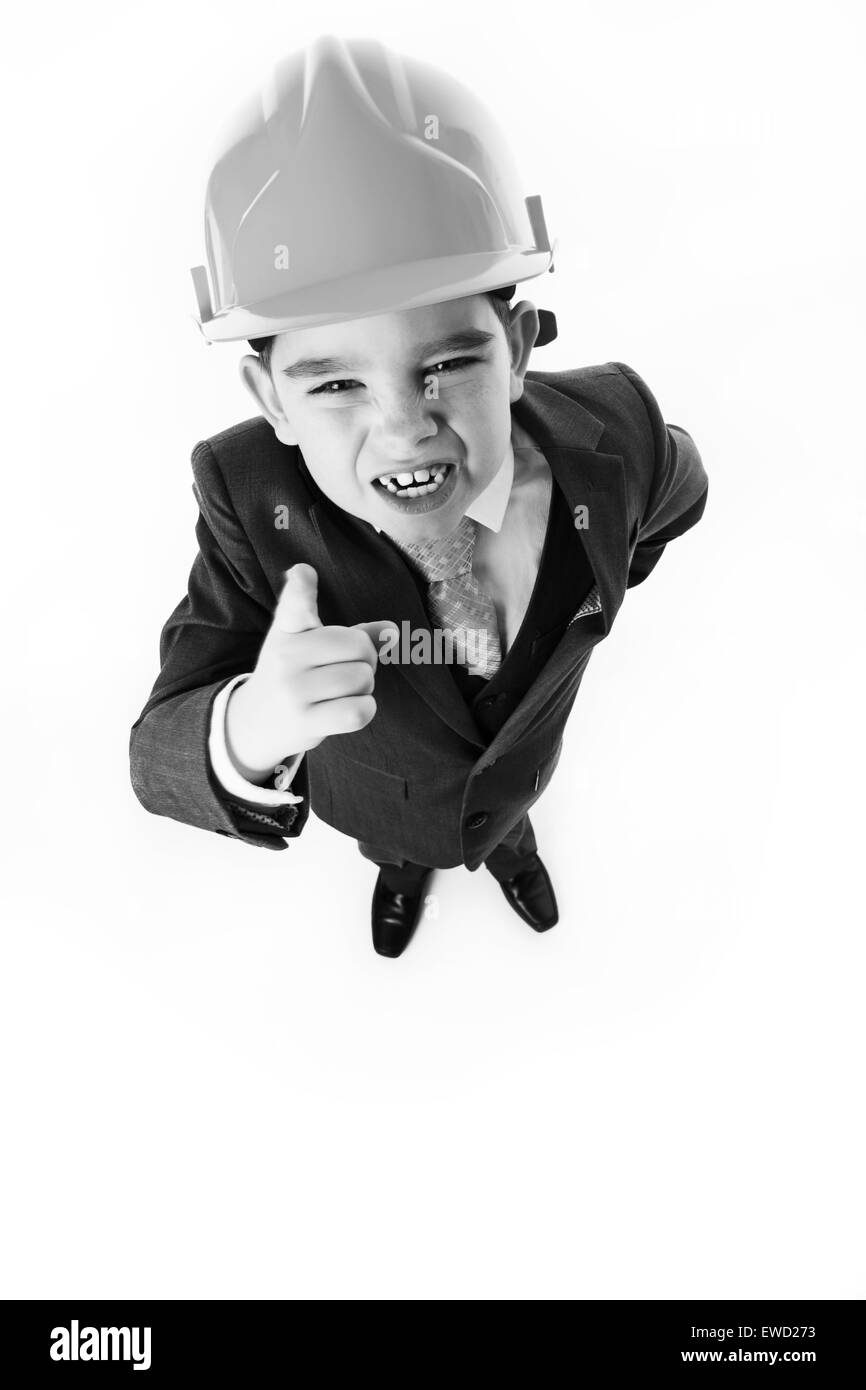 looking down at a young boy wearing a hard hat and hes shaking his finger at you Stock Photo