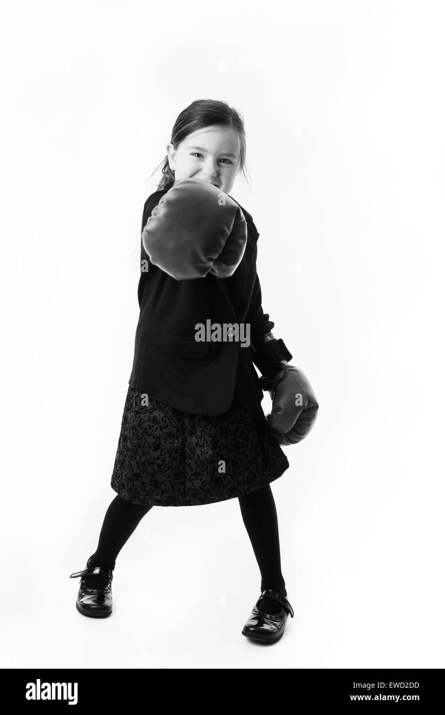 young girl dressed up as a business person wearing boxing gloves Stock Photo