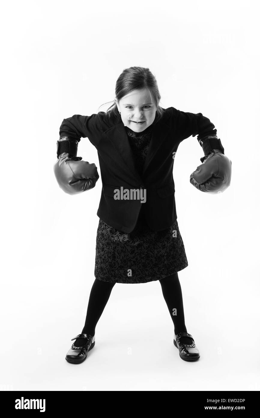 young girl dressed up as a business person wearing boxing gloves Stock Photo