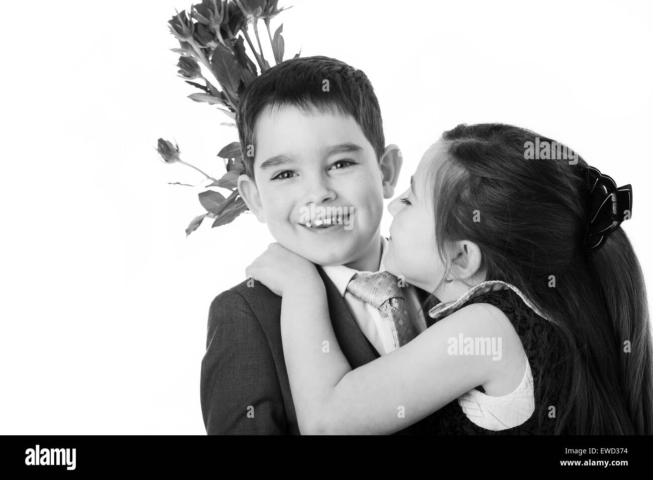 young boy dressed in a suit getting a kiss from a girl after given her some flowers Stock Photo