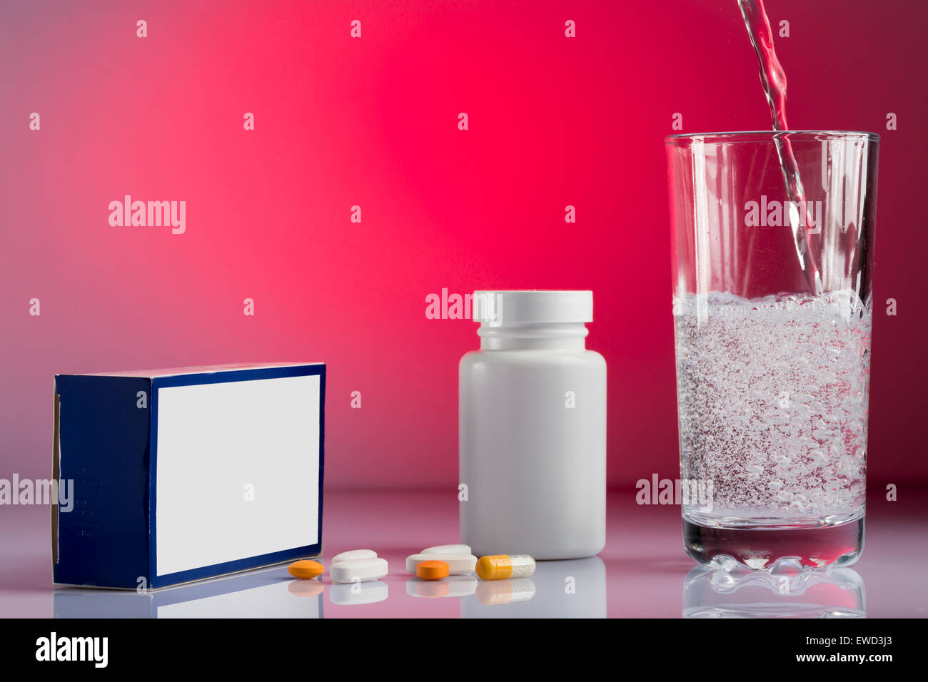 Various pills,box,bottle  and glass fizzy of water on colorful background Stock Photo