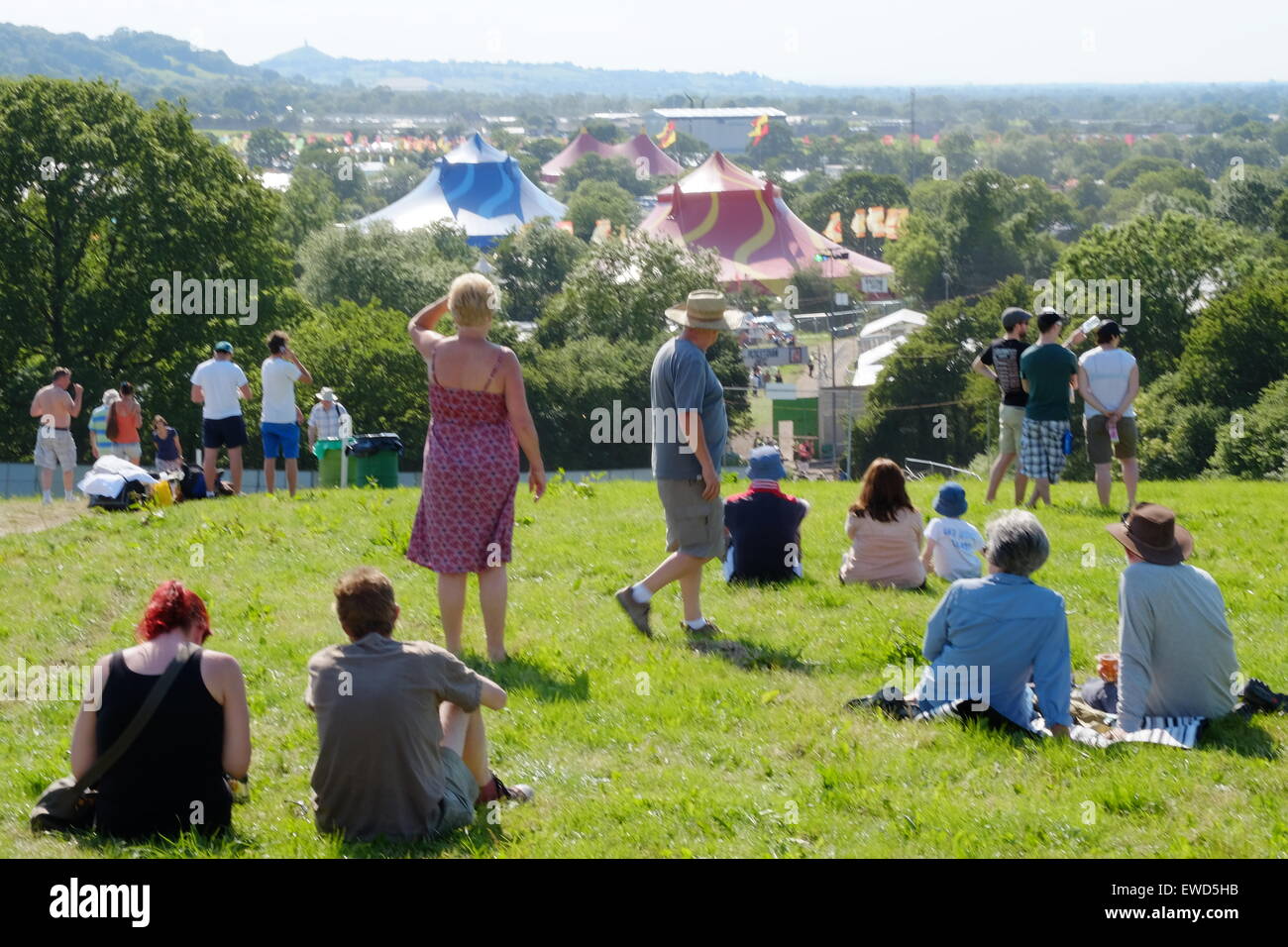 Glastonbury Festival, Somerset, UK. 23 June 2015. Early arrivers  sit on a hillside overlooking the Glastonbury Festival site in anticipation of the gates opening at 8:00 am tomorrow. Credit:  Tom Corban/Alamy Live News Stock Photo