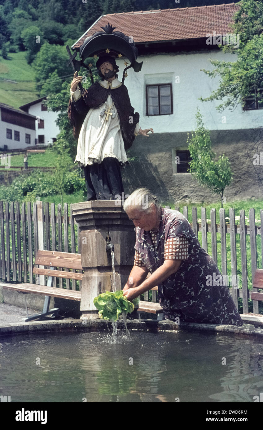 Woman washing salad in the water of the Dorfbrunnen of Ladis 1977 Frau wäscht Salat am Dorfbrunnen von Ladis. Stock Photo