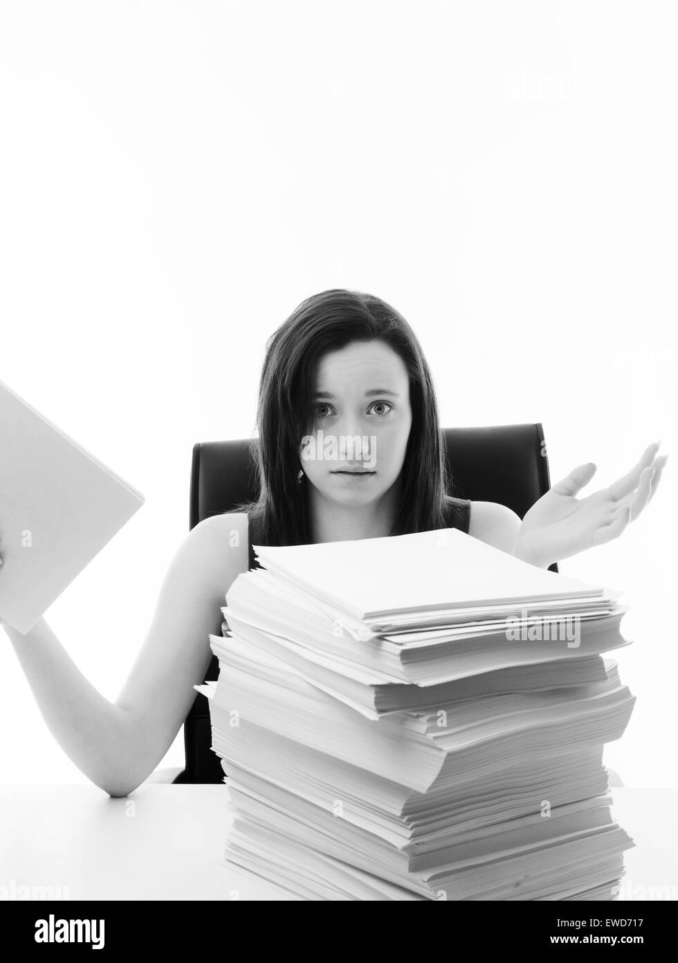 woman at a desk in the office with a very large stack of paper work in