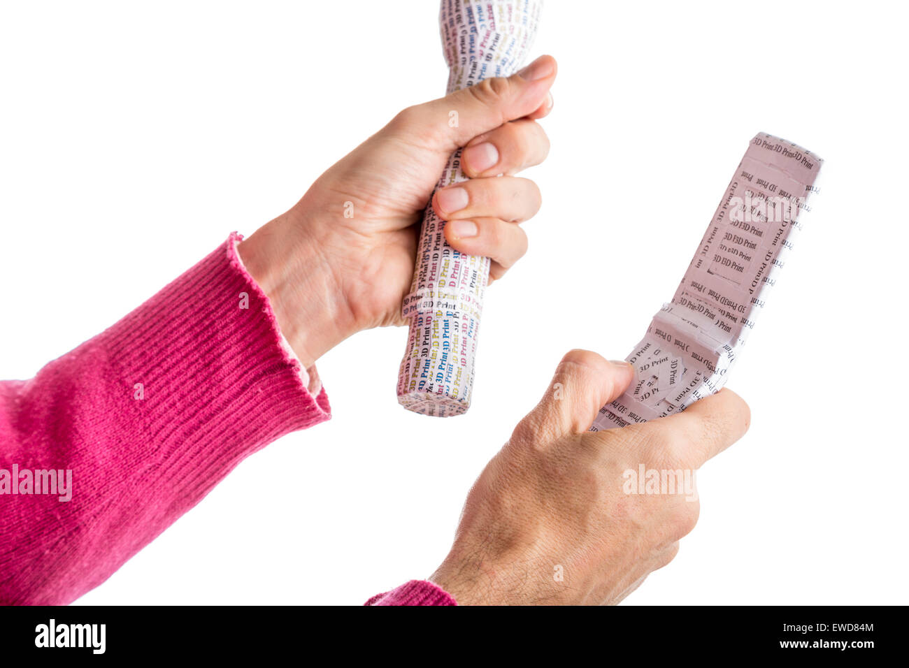 Adult hands in red sweater holding 3D Print labelled prototypes of white flashlight and clam shell mobile phone Stock Photo