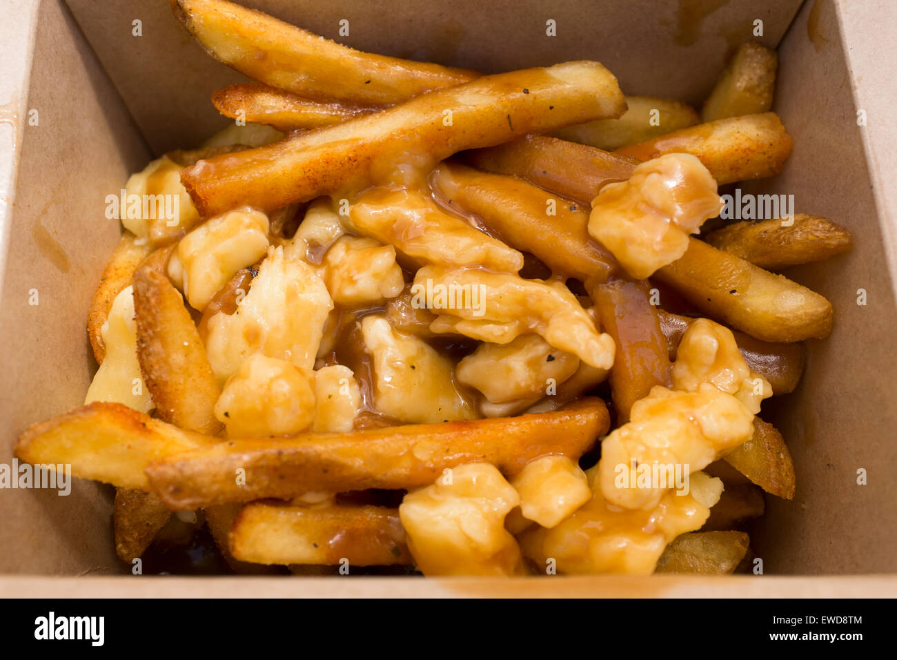 Poutine a Canadian delicacy of French Fries or chips with gravy and Cheese Curds on sale at