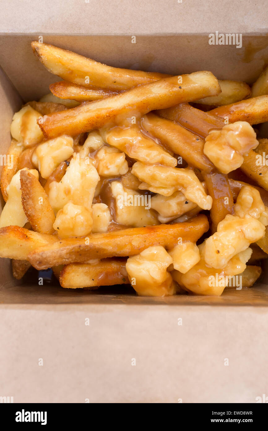 Poutine a Canadian delicacy of French Fries or chips with gravy and Cheese Curds on sale at