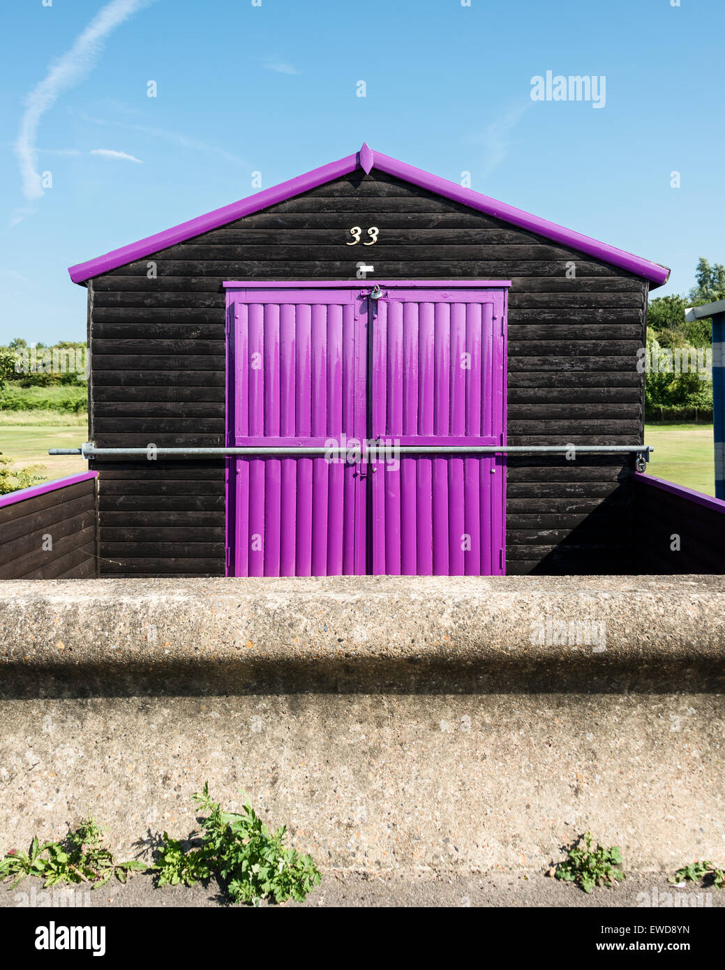 Black beach hut with purple double doors Stock Photo