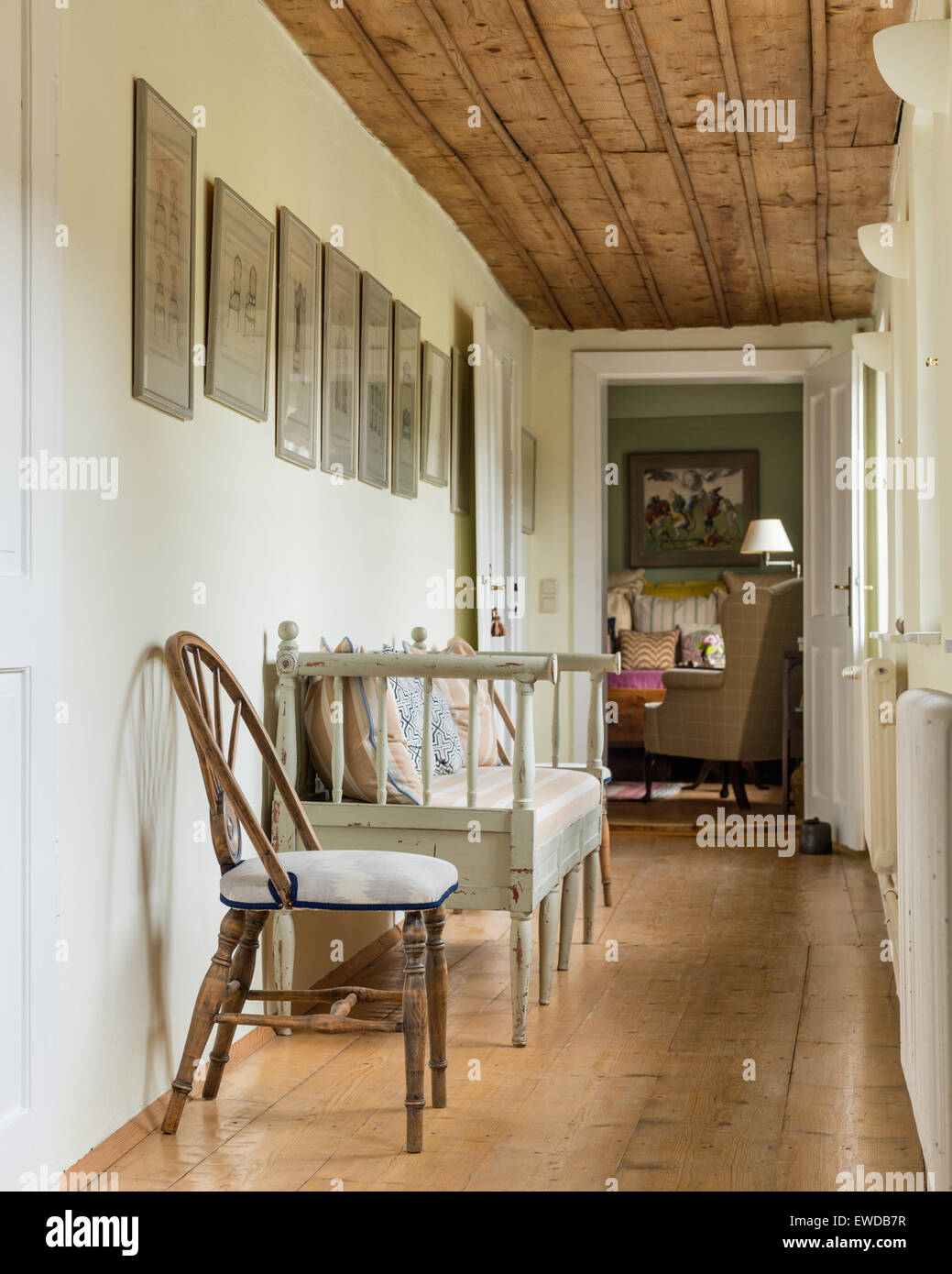 Scandinavian bench in corridor with wheelback chairs and french wall prints Stock Photo