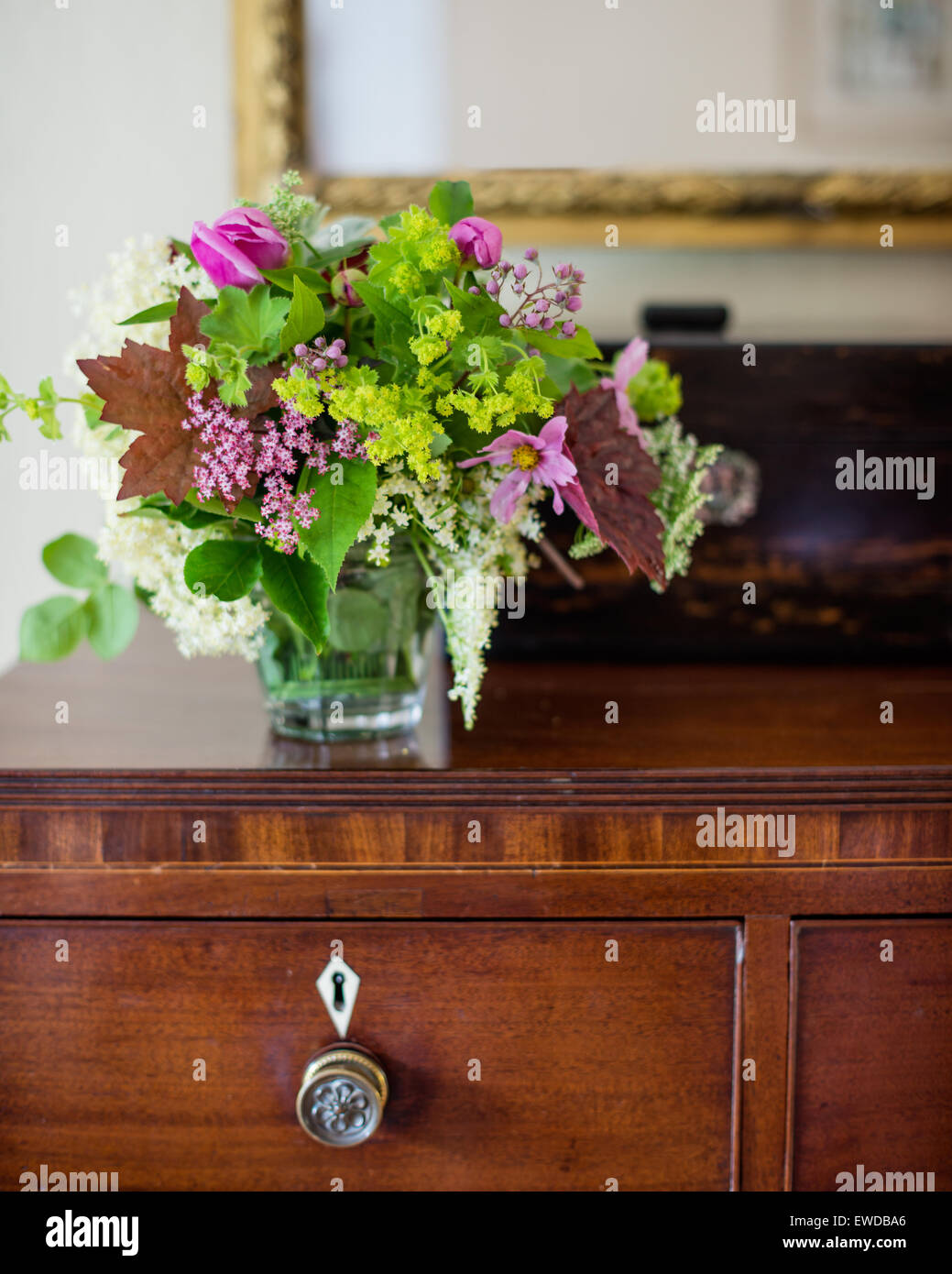 Posy of flowers on antique chest of drawers Stock Photo