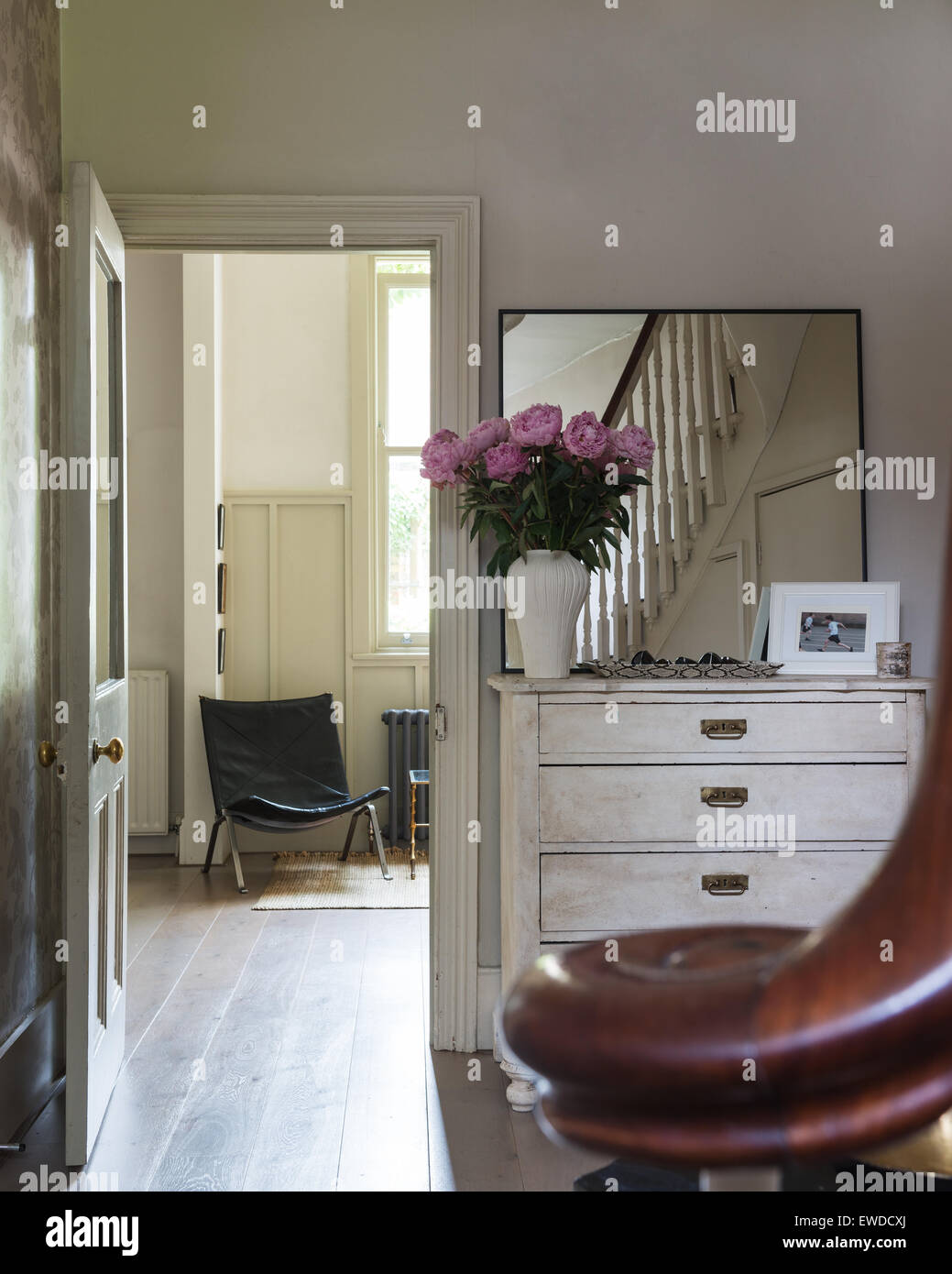 Simple square mirror on a white painted antique French chest in