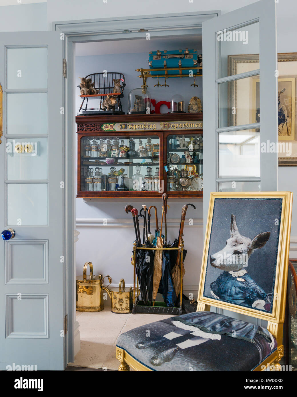 Upholstered Visitorian chair with sheeps head by Cory in entrance hall with umbrella stand and antique wall dresser Stock Photo