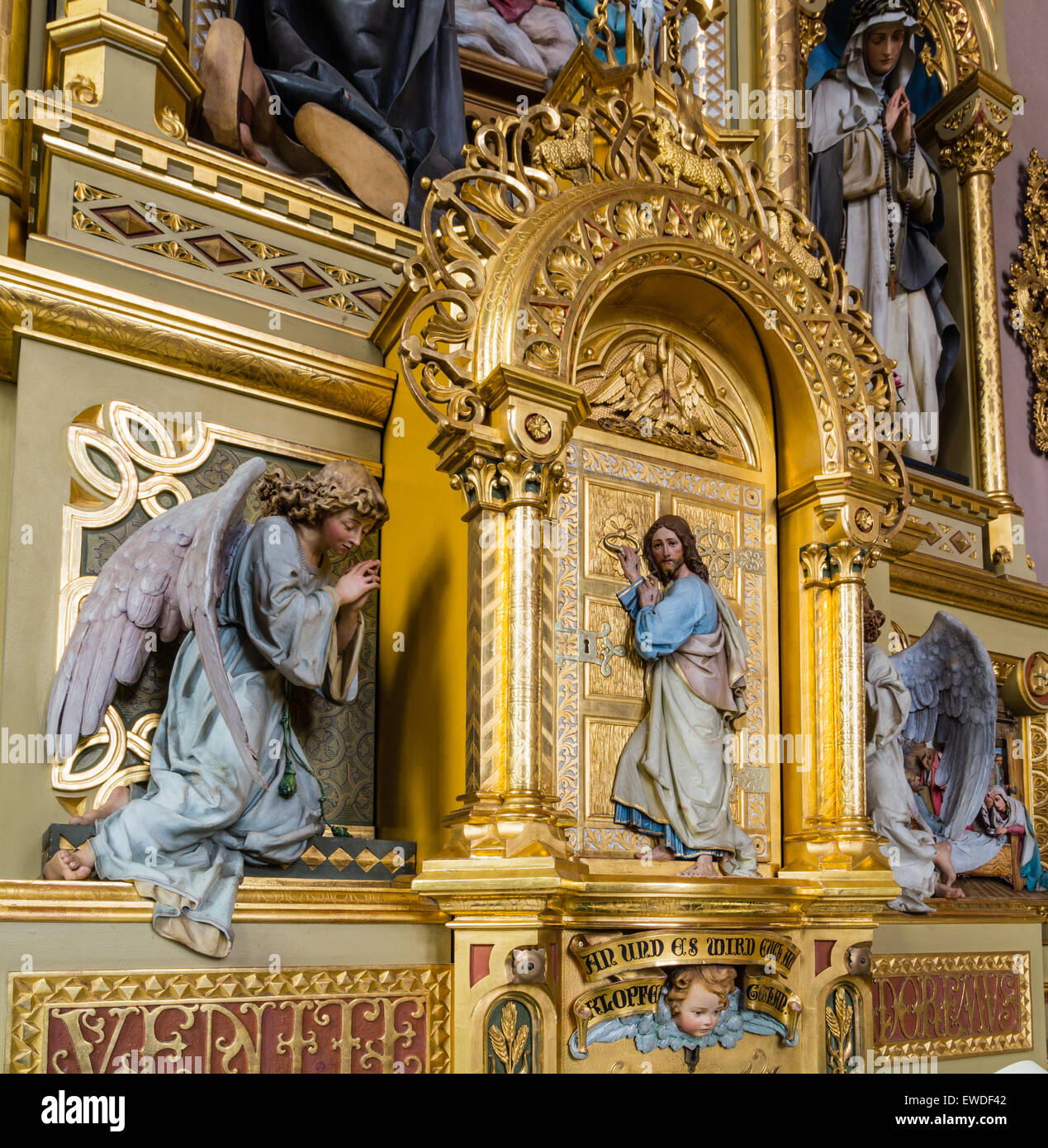 Wood carved statue of Jesus Christ between two angels standing at a